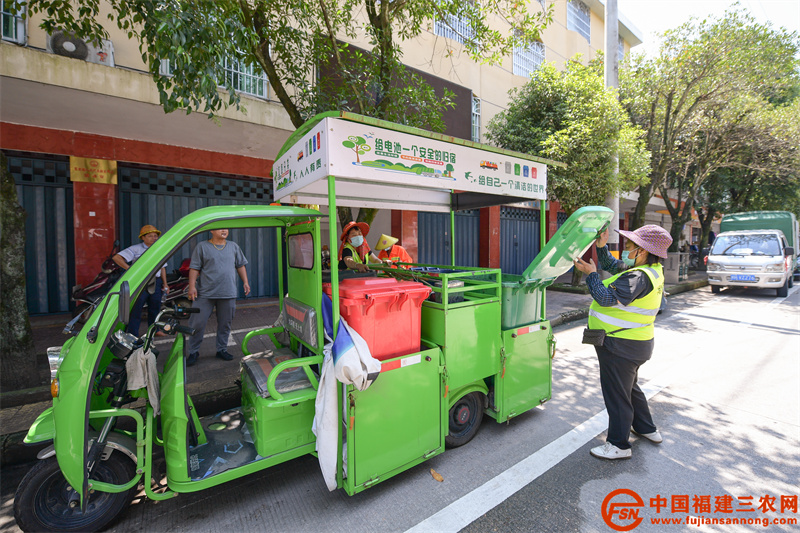 光泽县寨里镇环卫工人在街上进行路面清洁和垃圾分类收集。.jpg