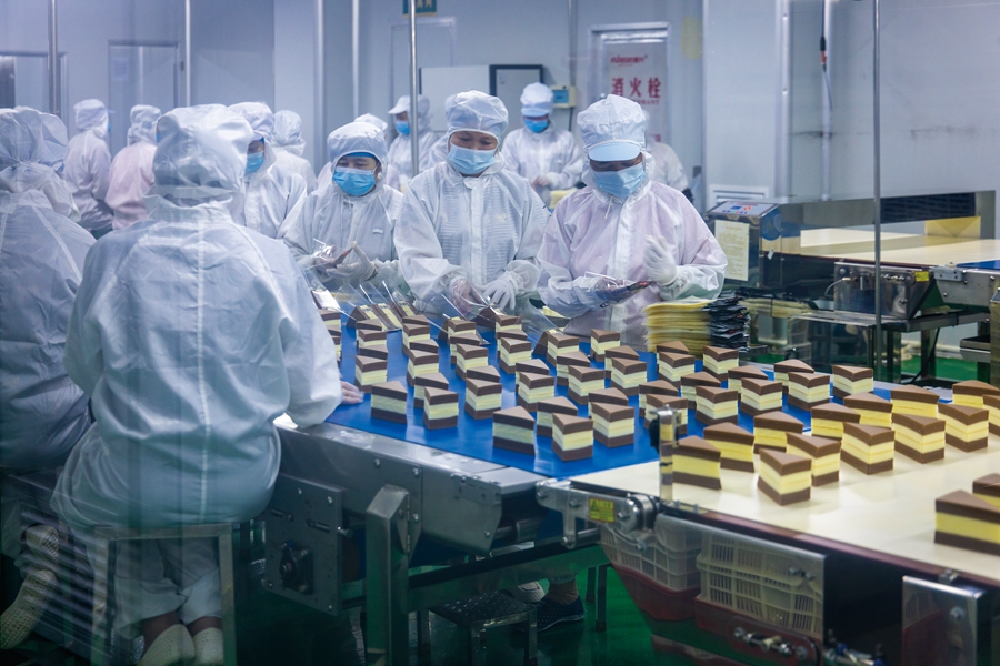 8月25日，在福建省漳州市龙海区一家食品企业，工人们忙着包装糕点。杨辉潜摄
