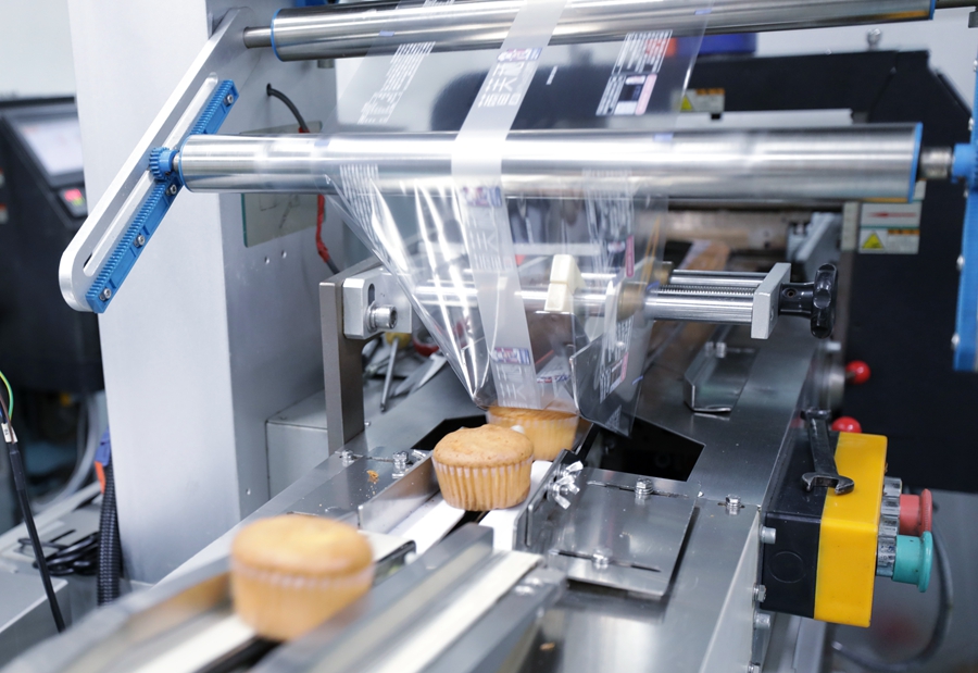 8月25日，在福建省漳州市龙海区一家食品企业，糕点通过机器完成包装。于莉摄