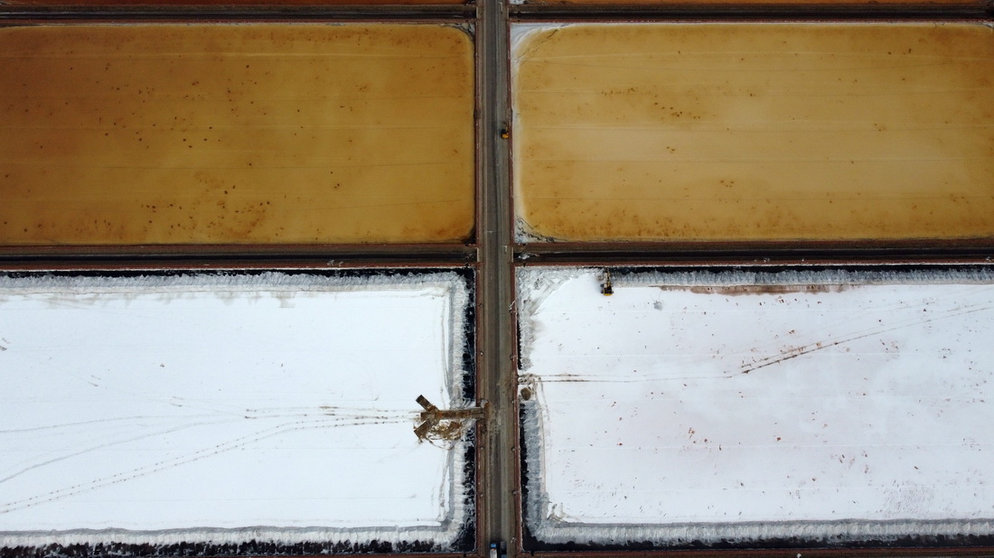 在天津长芦汉沽盐场，大型机械在盐池中进行扒盐作业（9月14日摄，无人机照片）。