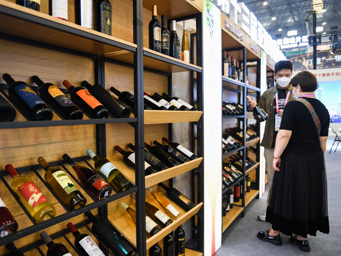 9月15日，参观者在亚洲葡萄酒展区了解商品。