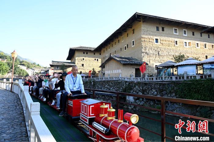 游客坐小火车游览南江村土楼。 张金川 摄