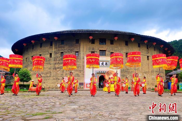 “大鼓凉伞”土楼前热闹上演。 永定土楼景区供图