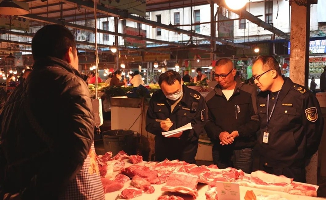 在凤尾农贸市场，市场监管局工作人员对违规使用“生鲜灯”的商户开出罚单。